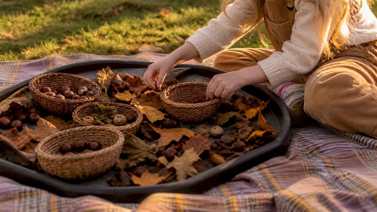 Child sorting autumn items in tuff tray