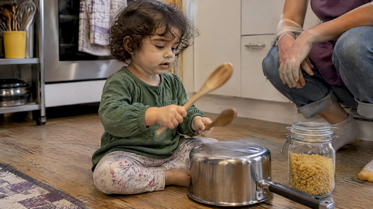 Toddler playing homemade kitchen instruments